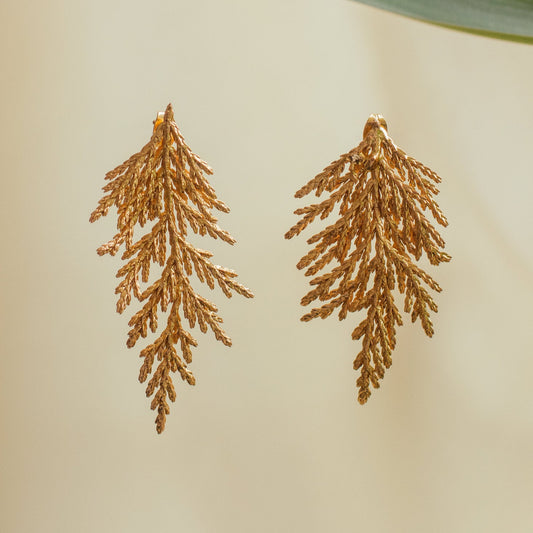 Aretes Hoja Pino Grande en bronce bañado en oro de 24k, destacando la belleza natural de las hojas de pino inmortalizadas