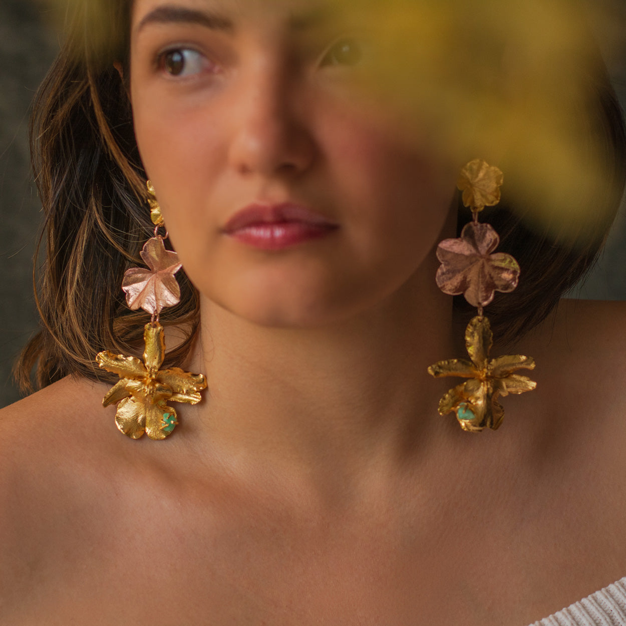 Elegantes aretes con orquídea Odontoglossum y hoja de hiedra inmortalizadas, adornados con esmeraldas