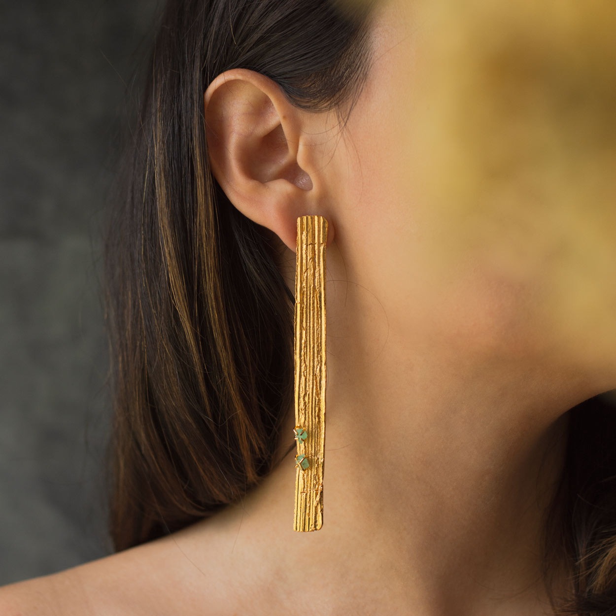 Aretes Corteza Palma Large Esmeraldas en bronce bañado en oro de 24k con esmeraldas colombianas, destacando la textura única de las cortezas de palma inmortalizadas